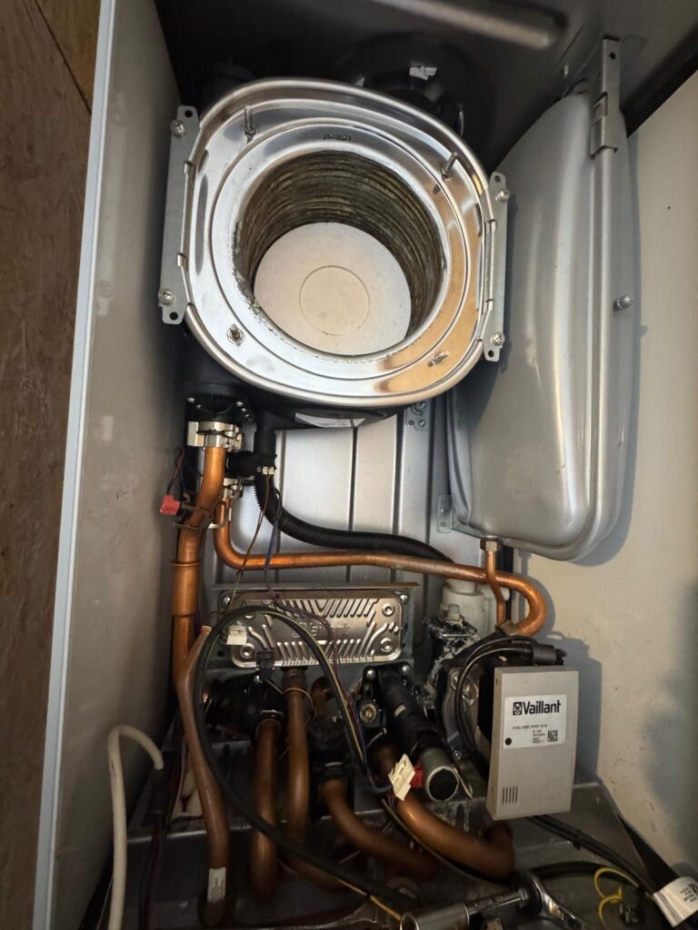 Vue intérieure d'une chaudière à gaz Vaillant ouverte pour un entretien ou nettoyage du corps de chauffe à Bruxelles.