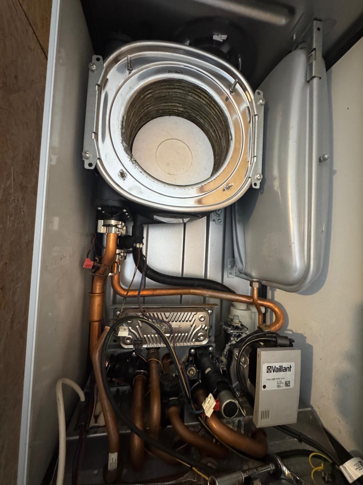 Chaudière au gaz Vaillant ouverte pendant un entretien, brûleur et échangeur visibles